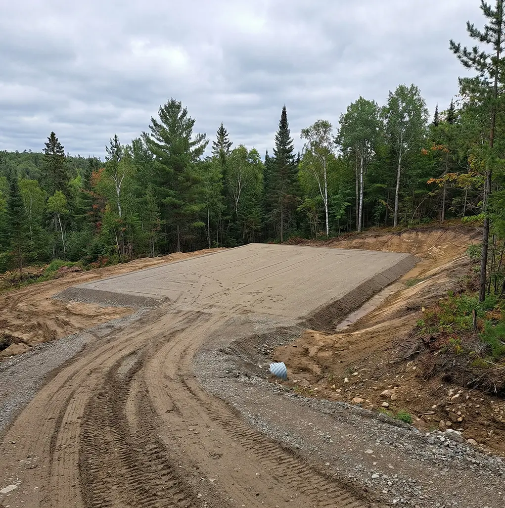 Prepared building pad with grading and compacted base for steel building construction in Canada