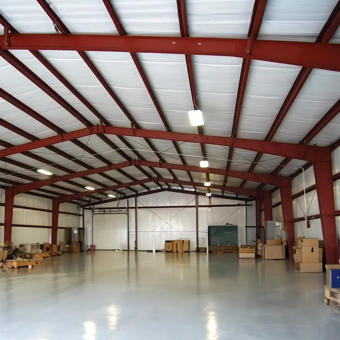 Interior steel building showing structural frame layout with beams, columns, and clear span space